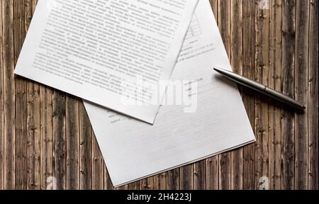 Penna e carta contratto sulla scrivania in legno Foto Stock