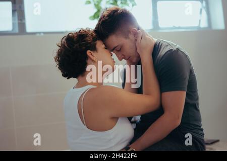 Due giovani amanti della queer che condividono un momento intimo. Due romantici amanti della coda che toccano la fronte con gli occhi chiusi. O affettuoso Foto Stock