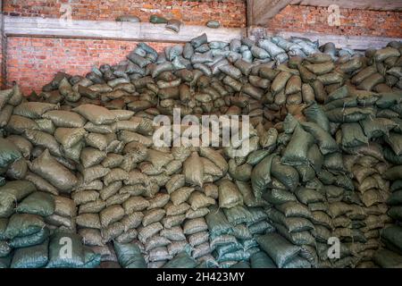 Montagne di articoli di sacco accumulati nel magazzino chimico Foto Stock