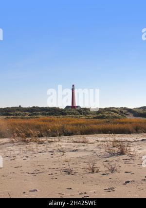 Uno dei fari di Schiermonnikoog, il Noordertoren, visto dalla spiaggia. Questa torre è di colore rosso chiaro. Si può vedere un po 'di sabbia e le dune. Cl Foto Stock