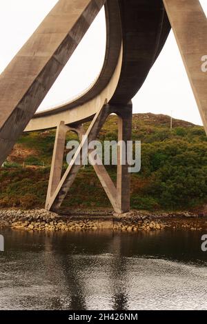 Una vista del ponte Kylesku , Sutherland, Scozia, che mostra la sua forma curva e gli enormi supporti sopra il Loch a Chairn Bhain Foto Stock