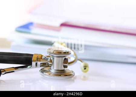 Stetoscopio con cartelle fild sulla scrivania medico in background Foto Stock