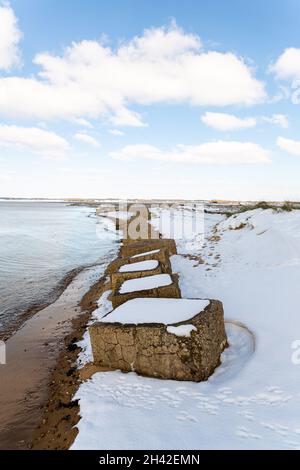 Trappole cisterna in cemento innevate lungo la costa britannica a Suffolk. Resti delle difese alleate per proteggere l'Inghilterra da un'invasione tedesca Foto Stock