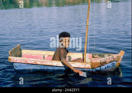 Africa, Egitto, Assuan, fiume Nilo 1976. Un ragazzo in una barca fatta in casa con un occhio dipinto sulla prua. L'occhio di tutti i vedente. L'occhio di Horus era un simbolo di protezione, salute e interezza. Foto Stock