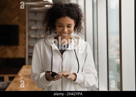 Sorridente giovane afroamericana usando il cellulare. Foto Stock