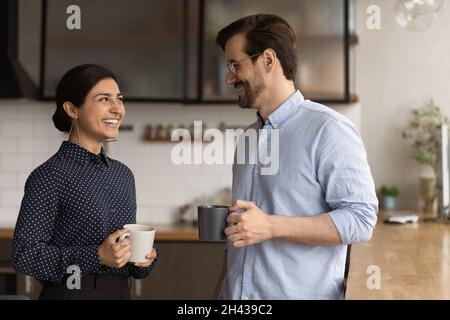 Felice dipendente indiano femmina che comunica con il collega maschio. Foto Stock