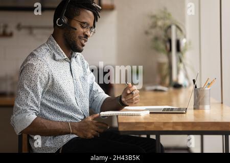 Sorridente giovane afroamericano che studia online. Foto Stock