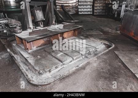 Pianale della fresatrice, attrezzatura dal fossato per lo scarico del liquido di raffreddamento, produzione di sporcizia nell'officina dello stabilimento industriale. Foto Stock