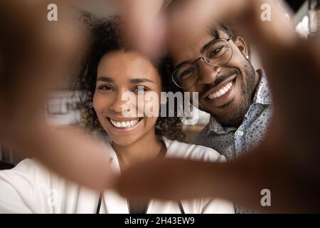 Primo piano sincera coppia afroamericana che mostra il simbolo del cuore. Foto Stock