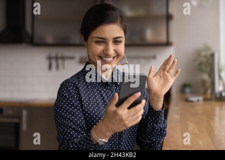 Felice giovane donna indiana che tiene una videochiamata mobile. Foto Stock
