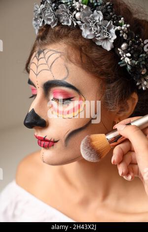 Giovane donna che si prepara alla celebrazione della Giornata dei morti del Messico (El dia de Muertos) Foto Stock