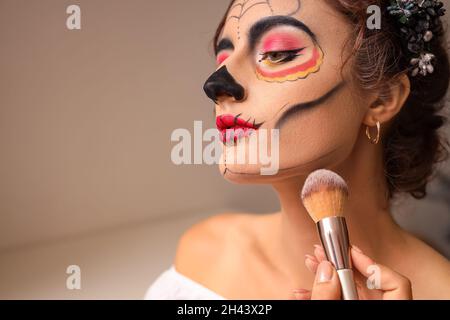 Giovane donna che si prepara alla celebrazione della Giornata dei morti del Messico (El dia de Muertos) Foto Stock