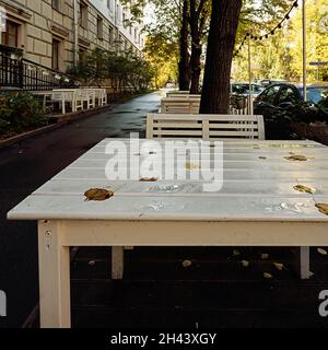 Tavoli vuoti di un caffè di strada in un giorno d'autunno. Foto Stock
