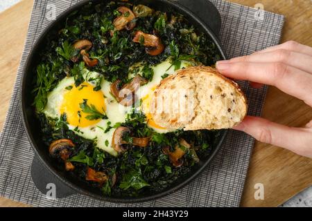 Donna che mangia Shakshouka gustoso a tavola Foto Stock