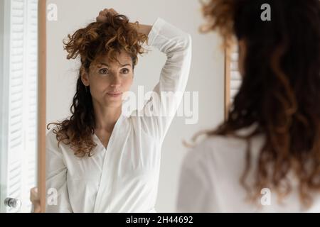 Bella giovane donna in accappatoio posa di fronte allo specchio Foto Stock