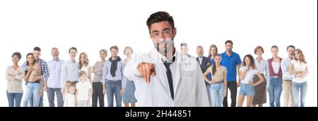 Ritratto del medico amichevole terapista che punta a voi e guardando la macchina fotografica con sorriso folla molte persone casual sullo sfondo, isolato su bianco Foto Stock