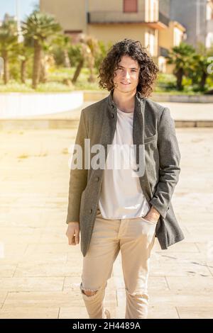 Uomo dai capelli scuri che cammina per strada Foto Stock