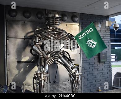 Un robot al di fuori del ristorante Robotazia che tiene una bandiera per dimostrare che è aperto. Foto Stock