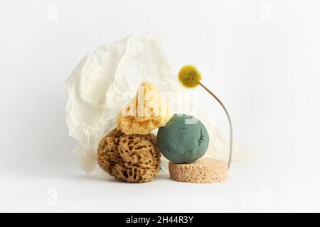 Spugne naturali, carta da imballaggio e fiore su bianco.Creative Concept photography Foto Stock