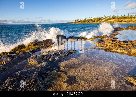 Le onde si infrangono contro la costa rocciosa e in una pouca a Kaopala Point, West Maui, Hawaii. Foto Stock