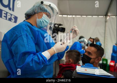 Un infermiere ottiene una dose dal flaconcino di vaccino SINOVAC mentre il governo colombiano inizia a vaccinare i bambini di età compresa tra 3 e 11 anni contro la malattia di Coronavirus (COVID-19) con il vaccino cinese SINOVAC, a Bogota, Colombia, il 31 ottobre 2021. Foto Stock