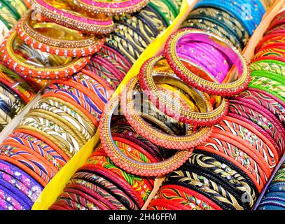 Angolature colorate indiane visualizzate in negozio locale in un mercato di Pune, India, questi angoli sono fatti di vetro usato come accessori di bellezza da donne indiane Foto Stock