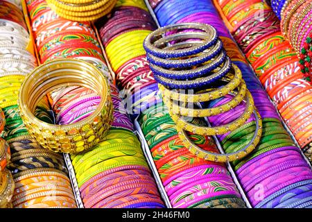 Angolature colorate indiane visualizzate in negozio locale in un mercato di Pune, India, questi angoli sono fatti di vetro usato come accessori di bellezza da donne indiane Foto Stock