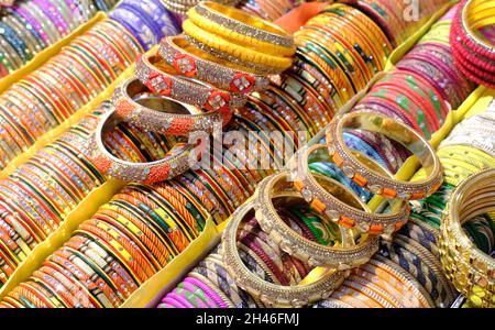 Angolature colorate indiane visualizzate in negozio locale in un mercato di Pune, India, questi angoli sono fatti di vetro usato come accessori di bellezza da donne indiane Foto Stock