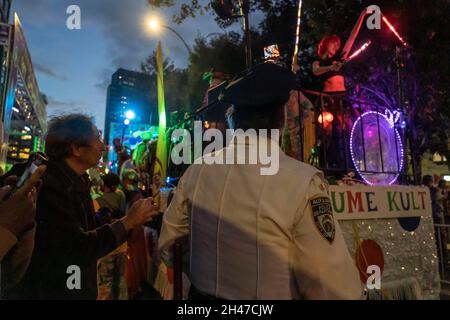 New York, Stati Uniti. 31 ottobre 2021. Un ufficiale di polizia di New York guarda le luci di un artista durante la 48a annuale Parata di Halloween del Villaggio di New York City a New York City. Il tema di quest'anno è "Let's Play", dedicato ai bambini di New York che non hanno avuto un halloween adeguato nel 2020. L'anno scorso la sfilata, così come numerosi altri eventi di Halloween, sono stati cancellati o ridimensionati a causa della pandemia del coronavirus. Credit: SOPA Images Limited/Alamy Live News Foto Stock