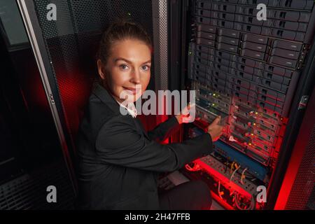 Tecnico informatico che lavora con il server di backup nei rack Foto Stock