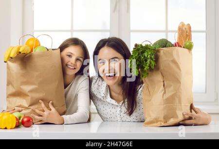 Felice madre e bambino con borse di alimentari pieno di cibo sano dal mercato biologico Foto Stock
