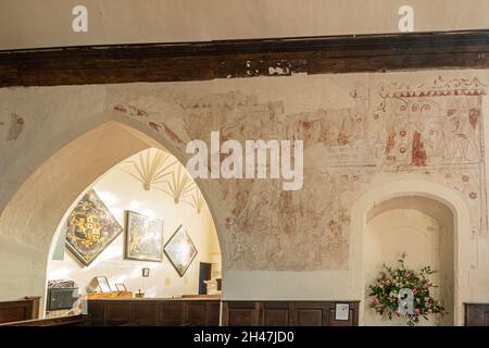 Dipinti murali storici all'interno della chiesa di St James, villaggio di Bramley, Hampshire, Regno Unito, un edificio classificato di grado I. Pittura dell'omicidio di Thomas Becket Foto Stock