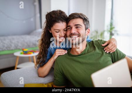 Bella giovane coppia amorevole rilassarsi mentre la donna abbraccia il suo ragazzo e sorridente Foto Stock
