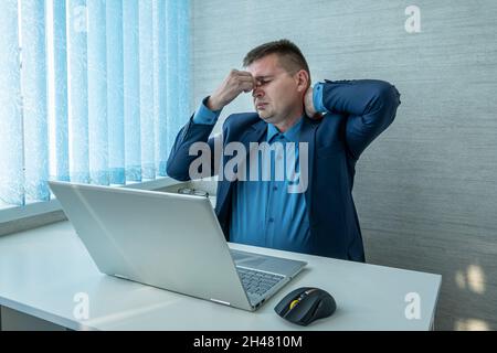 ritratto di giovane uomo stanco triste che copre gli occhi pieni di dolore e stress che hanno fatica. Stressante bell'uomo caucasico cercando di concentrarsi, trovare sol Foto Stock