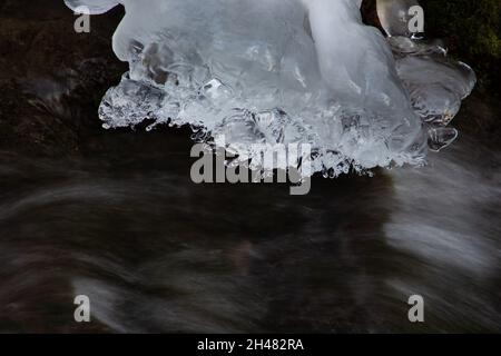 Acqua che scorre sotto ghiaccio fondente, concetto di riscaldamento globale Foto Stock