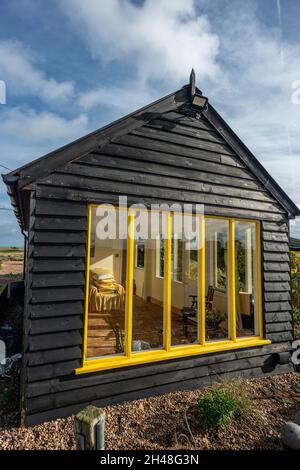 Dungeness, 30 ottobre 2021: La casa defunto di Derek Jarman, Prospect Cottage sulla spiaggia di ghiaia a Dungeness nel Kent Foto Stock