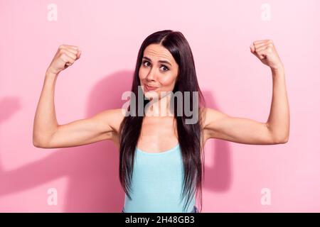 Ritratto di attraente funky forte ragazza cheery dimostrazione muscoli isolati su sfondo rosa pastello colore Foto Stock