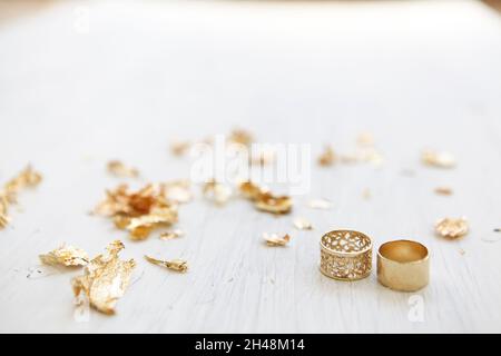Anelli di nozze dorati su sfondo bianco di legno Foto Stock