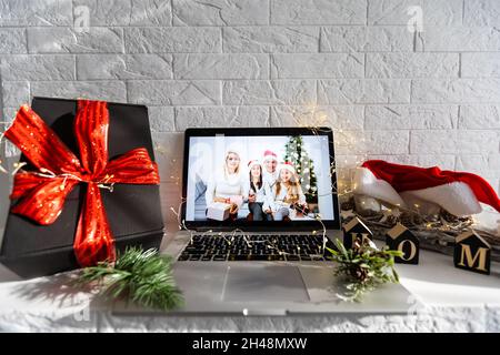 Giorno di Natale Virtual meeting team telelavoro. Videochiamata di famiglia in conferenza remota. Visualizzazione dello schermo della webcam del computer portatile. Diversi ritratti si incontrano Foto Stock