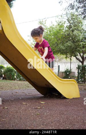 Il bambino gioca in un parco giochi all'aperto. Versione modello disponibile Foto Stock