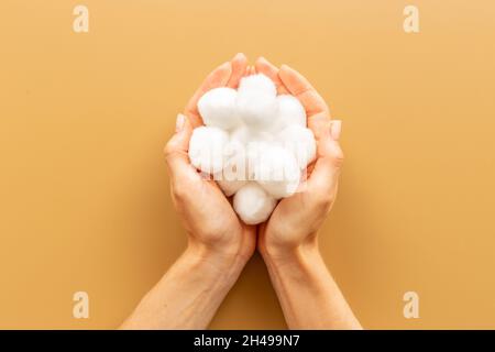 Batuffoli di lana di cotone nelle mani femminili - pulire e curare la pelle Foto Stock