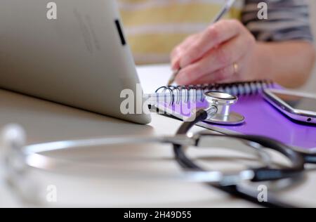 dottore che usa il computer tablet e la tastiera per ipad, norfolk, inghilterra Foto Stock