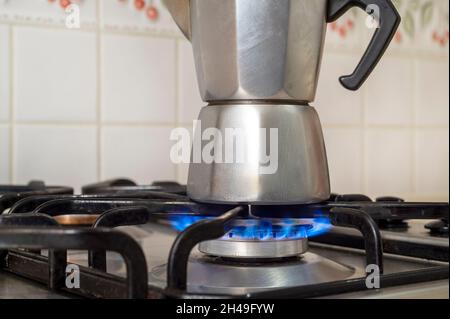 gas che brucia da una stufa a gas della cucina che riscalda una caffettiera Foto Stock