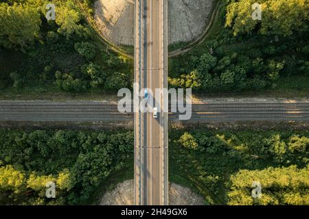 Vista aerea dall'alto verso il basso sul viadotto dell'autostrada via ferrovia. Vista del ponte con auto sulla ferrovia. Attraversando la linea ferroviaria e l'autostrada Foto Stock