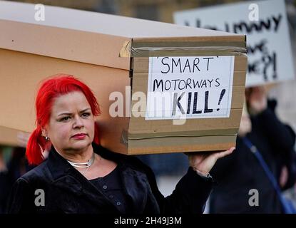 I dimostranti che protestano contro le autostrade intelligenti marciano con le casse attraverso il Ponte di Westminster fino a Piazza del Parlamento a Londra. Data foto: Lunedì 1 novembre 2021. Foto Stock