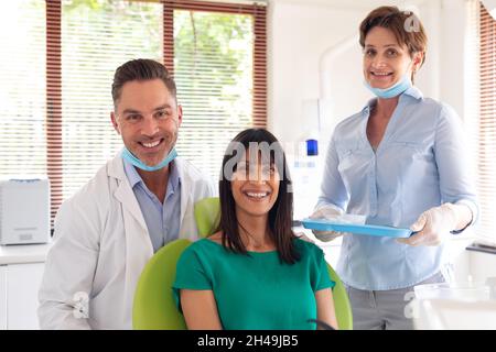 Ritratto di dentista, infermiere dentista e paziente sorridente nella moderna clinica dentale Foto Stock