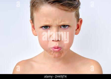 Capretto con faccia triste, ragazzino sconvolto, bambino caucasico infelice guardando fuori, capretto viziato in piedi da solo facendo labbra pointy, bambini viziati concetto. isol Foto Stock