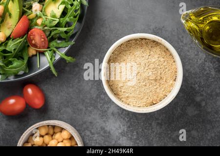 Fiocchi di lievito nutrizionali in un recipiente in ceramica. Cibo a base di piante Foto Stock