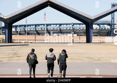 Tre giovani uomini camminano su una rampa portandoli da Flushing Meadows Corona Park a Citi Field e il treno della metropolitana numero 7. A Queens, New York. Foto Stock