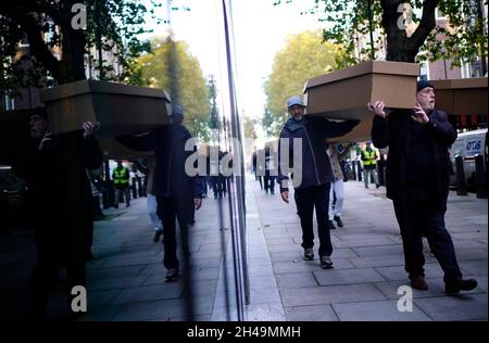 I dimostranti che protestano contro le autostrade intelligenti marciano con le casse attraverso il Ponte di Westminster fino a Piazza del Parlamento a Londra. Data foto: Lunedì 1 novembre 2021. Foto Stock